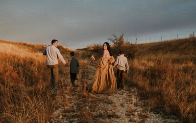 A family of six walk up a rocky road wearing coordinating outfits in fort worth texas