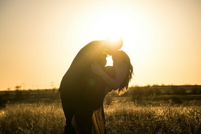 Couple kissing at sunset, symbolizing emotional connection and future alignment through premarital counseling