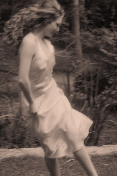 Ballet dancer spins around in Sewanee by a small creek with a slow shutter speed.