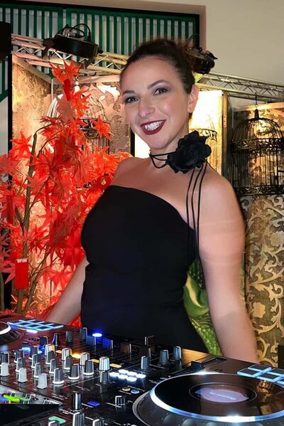Female DJ using top end sound system, lights and smoke machines