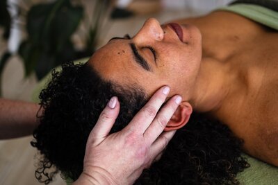 Katie's hands on a clients head for reiki session.
