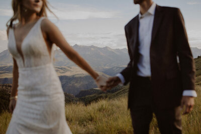 Couple walks through mountains holding hands