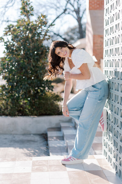 Senior photo of girl standing in casual pose smiling in sunshine