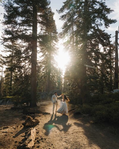 bride and groom standing under trees