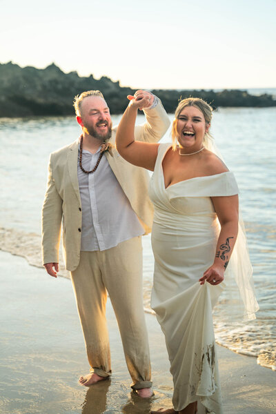 Couple playing on beach, taken by big island hawaii wedding photographer