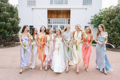 bride and bridesmaids standing in purple dresses