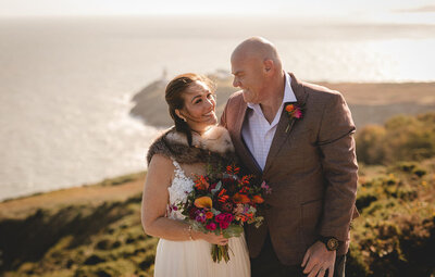 Bride and groom smiling at each other at Howth Cliff Walk for their micro wedding  in Dublin, Ireland