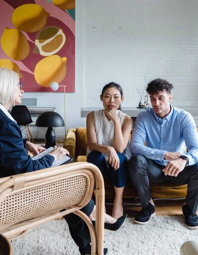 Man and woman sitting on a couch talking to a therapist