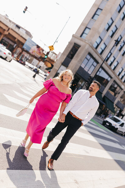 engaged couple holding hands and waling downtown 