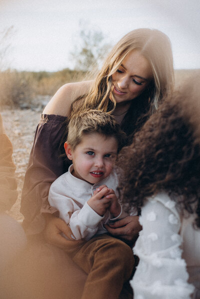 Mom holding son in her lap on a blanket in the Scottsdale desert