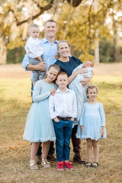 A family of four wearing casual clothing at a park in Summerville SC