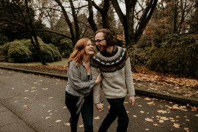 woman holds her fiance's arm and laughs during engagement session in Volunteer Park