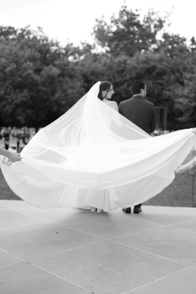 bride's train is fluffed before walking down the aisle at Nelson-Atkins Museum wedding ceremony
