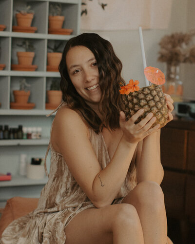 Girl holding pineapple in studio
