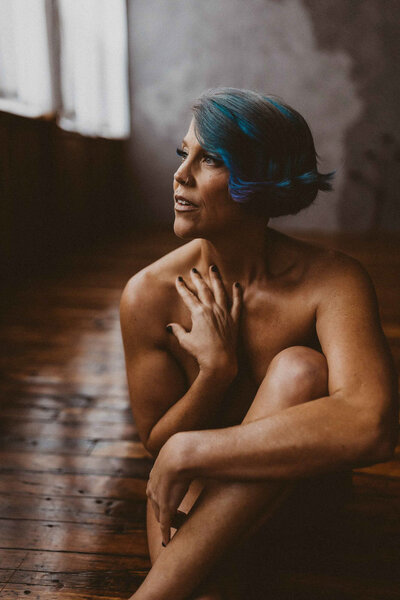 blue haired woman sitting on the floor