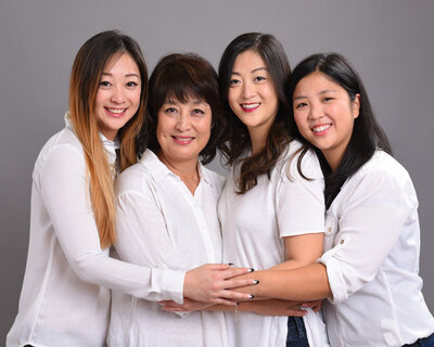 Mom with daughters hugging for portrait with white shirt