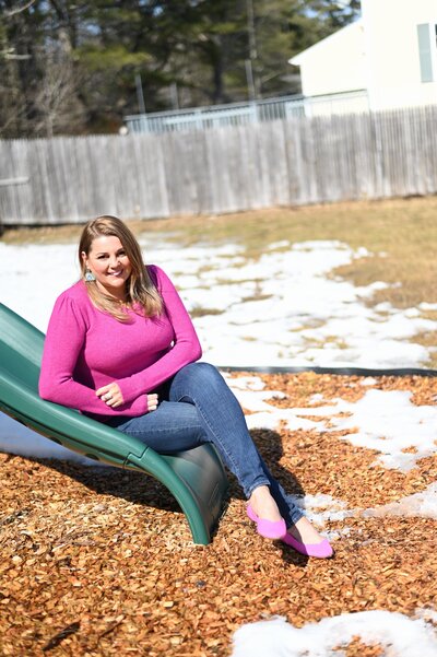 Mrs. Hanscome sitting on the slide at House of parker preschool in Gorham, ME