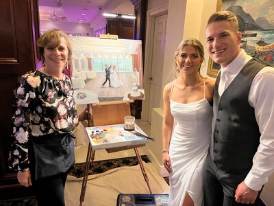 Linda Marino with bride and groom posing with wedding art
