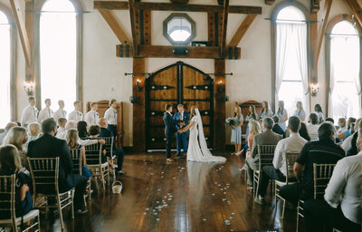Wadley Farms ceremony inside castle couple holding hands inside great room