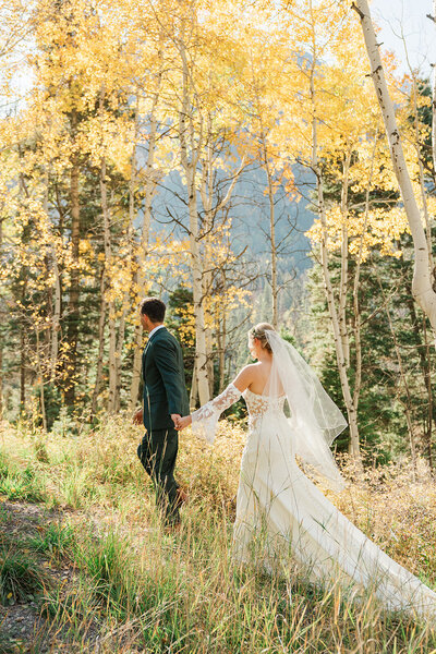 The groom hugs the bride while they laugh in a fall aspen forest in Breckenridge