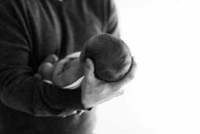 Father holding his newborn baby in his hands, black and white photo