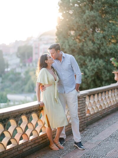 Romantic engagement session at golden hour overlooking Taormina, with a couple sharing a tender moment — Portfolio Thomas Raboteur Wedding Photographer.