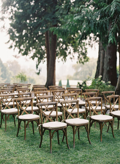 Outdoor ceremony seating with wooden chairs.