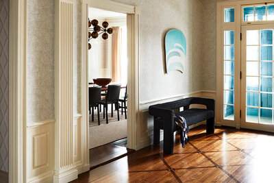 Historic home designer Boston updates a foyer with original architectural details, modern art, and contemporary furniture for a fresh classic look.