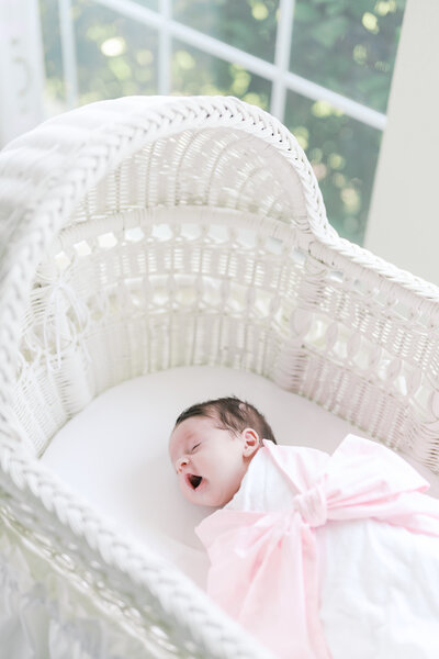 Close-up of newborn feet held by mother in crib during a luxury in-home session