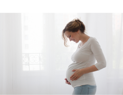 pregnant woman with hands holding her baby bump