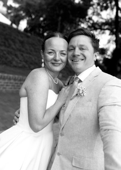bride and groom smiling in a black and white photo