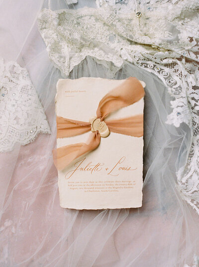 Minimalist peach wedding invitation with deckle edges and plant-dyed silk wrap