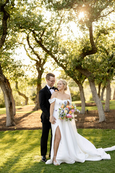 Bride and groom share a quiet moment in golden hour light beneath oak trees, styled and planned by an Austin wedding planner.
