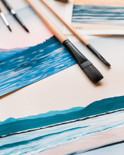 Closeup photo of paintbrushes on a gouache painting by Amy Duffy