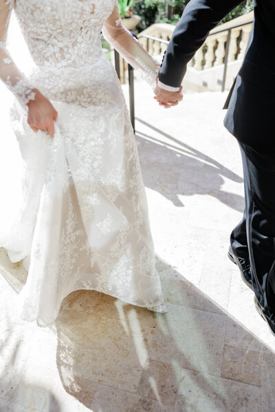 Wedding couple at the Ritz Carlton Sarasota in front of a floral arch at their ceremony by Angelika Krug Photo & Film