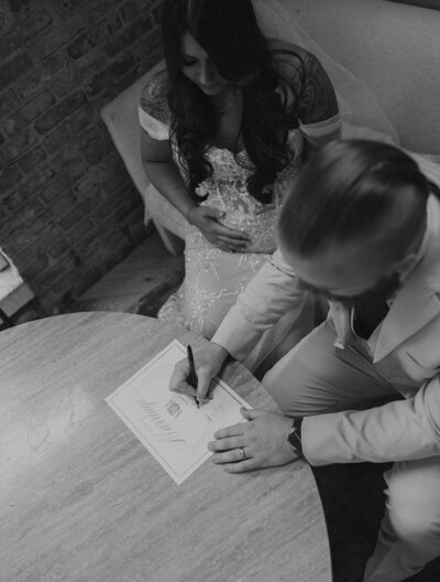 new bride and groom signing marriage license after ceremony at hotel vacancy courtyard elopement in kc