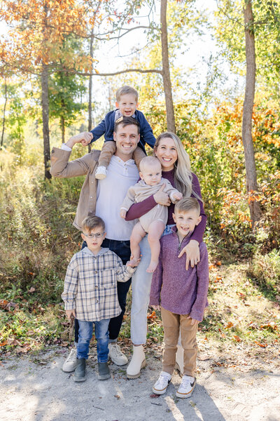 Family gathered together smiling at the camera at a park in Centerville, Ohio in the Fall.