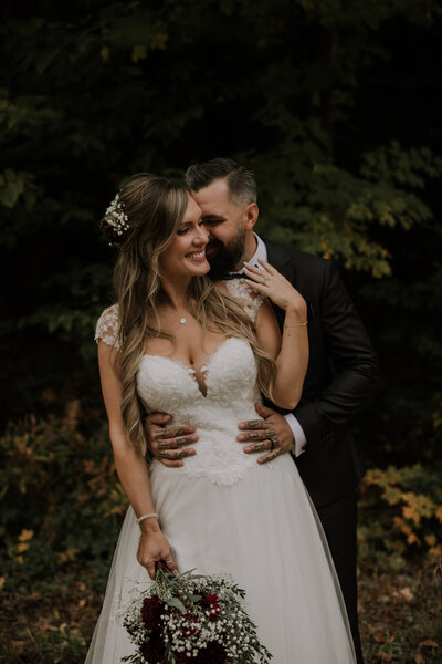 wedding couple hugging by the water