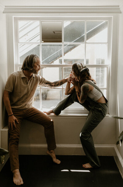 Intimate at-home couple's session by the large window
