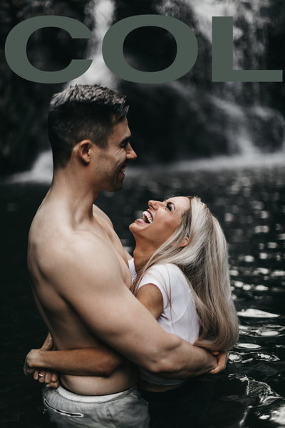 Couple hugging and laughing in waterfall
