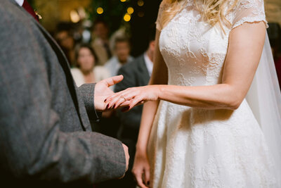 a bride and groom exchanging rings at cripps hall