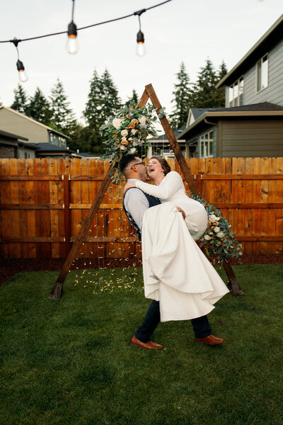 man picking up woman after getting married