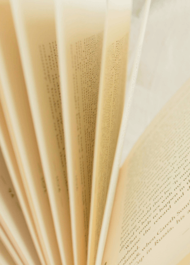 Close-up of pages in an open book, symbolizing academic depth, intellectual curiosity, and professional grounding.