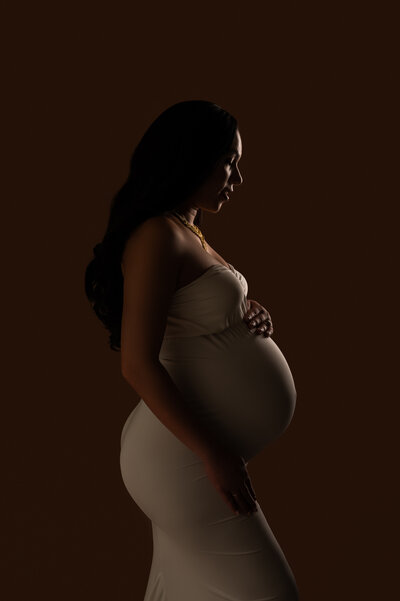 Tasteful nude maternity portrait with expectant mother looking into the distance