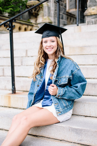 Georgetown University senior in cap posing on steps for portrait session