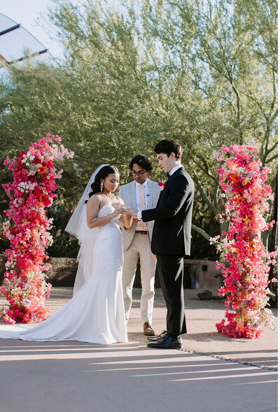 Wedding flowers at Desert Botanical Garden Phoenix features bougainvillea floral arrangements and flower arch designed by Snapdragon Bloom Bar