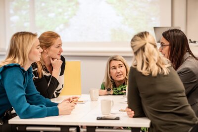 porträttfoto av två leende kvinnori naturlig miljö