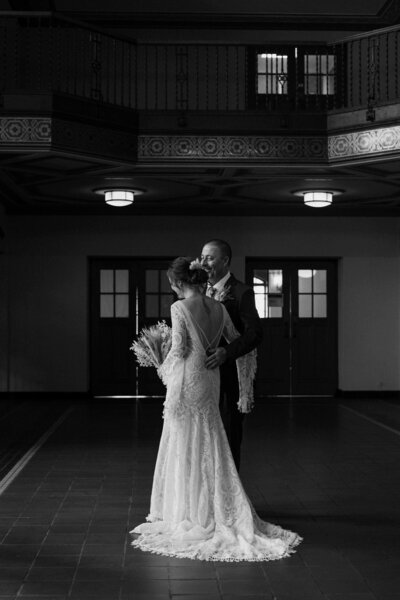 A person with an arm around their partner on their wedding day 