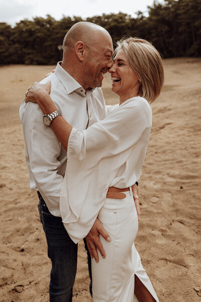 Koppel kijkt elkaar liefdevol aan tijdens loveshoot in Antwerpen