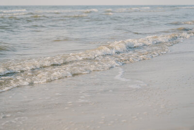 Gentle beach waves under soft skies on the Galveston Texas coast, captured in fine art documentary style by a luxury wedding and travel photographer.
